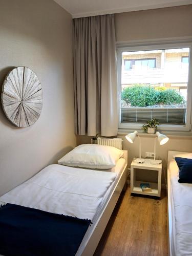 a bedroom with two beds and a window at Haus Triton in Büsum