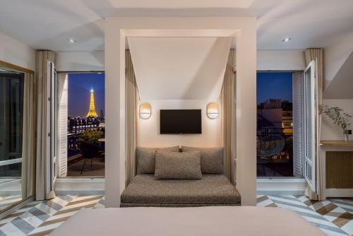 a bedroom with a view of the eiffel tower at Hôtel Atala Champs Elysees in Paris