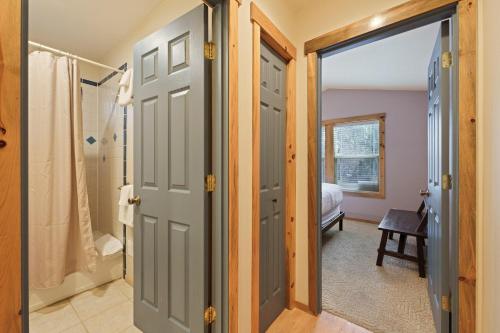 a bathroom with a walk in shower and a door at Huckleberry Cottage in Bend