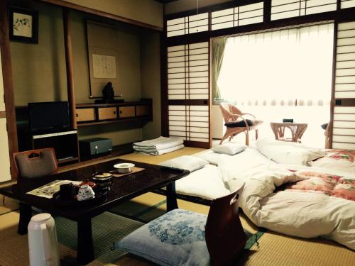 a living room with a bed and a table at Yudanaka Onsen Yamazakiya in Yamanouchi