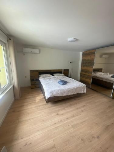 a bedroom with a bed and a wooden floor at Апартамент ФЕРДИНАНД in Ruse
