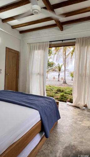 a bedroom with a bed with a view of the beach at Playa Mulata in Moñitos