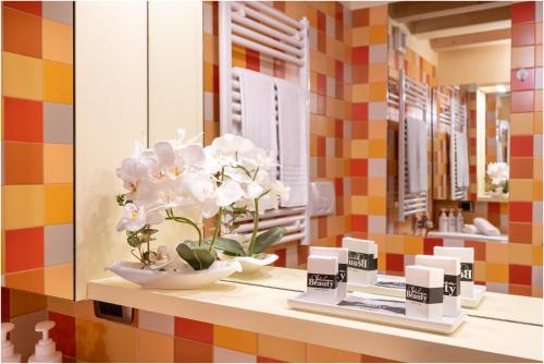 a shelf with a vase of flowers and a mirror at Casa Nova in Burano