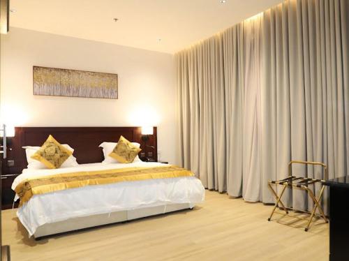 a bedroom with a large bed in a room with curtains at قصر الرحابة للشقق المخدومة in Hawāyā