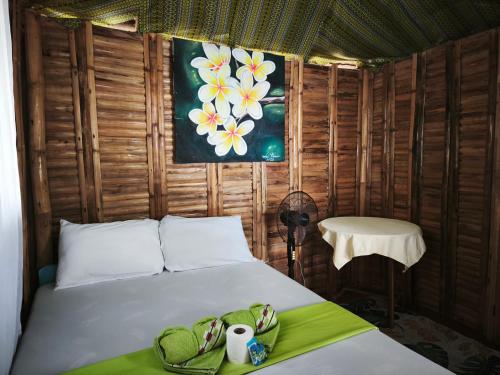 a bedroom with a bed and a painting on the wall at NATUA'S BEACH RESORT in Liminangoon