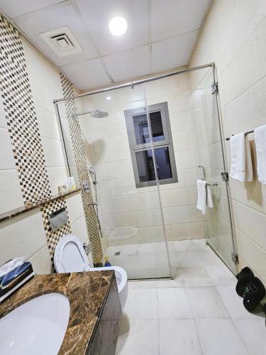 a bathroom with a shower and a toilet and a sink at Golden Homes 2 in Dubai
