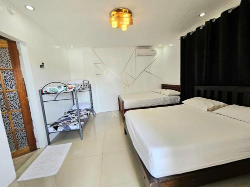 a bedroom with two beds and a shelf with shoes at Crestscente Skye Villa Resort in Pañgil