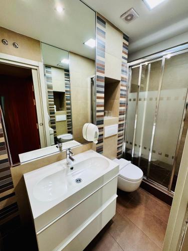 a bathroom with a sink and a toilet and a mirror at Hostal Sol Square Madrid in Madrid
