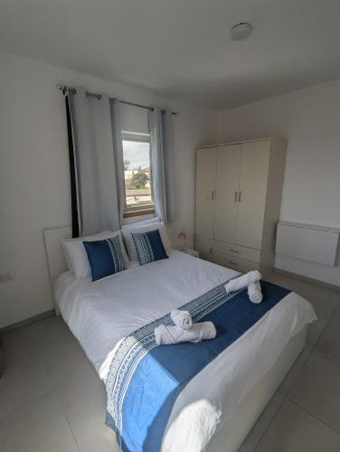 a bedroom with a large bed with towels on it at הבית הכחול in Haspin