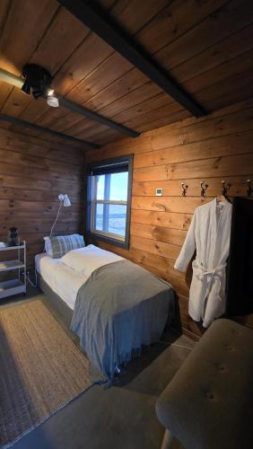a bedroom with a bed in a room with wooden walls at Riverfront Lodge Hella in Hella