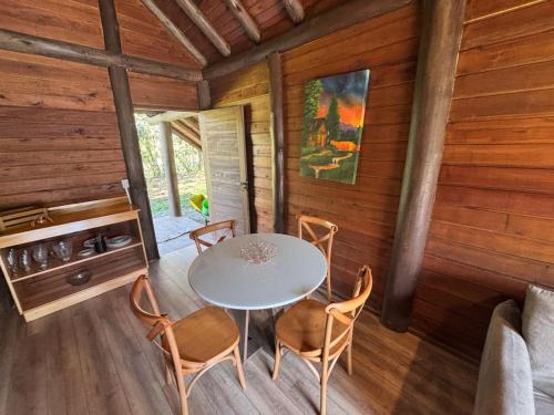a dining room with a table and chairs in a cabin at refugio in Aguas Mornas