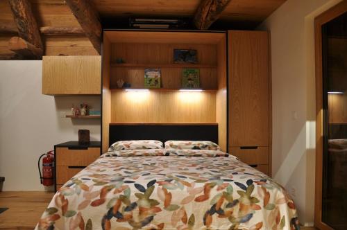 a bedroom with a bed and wooden cabinets at Rustico La Stalla a Pianezza in Menzonio
