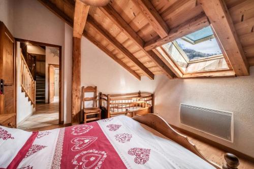 a bedroom with a bed in a room with a skylight at La Ferme de Sous-Lachat in Samoëns