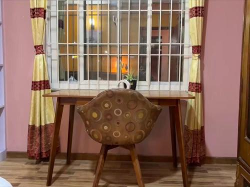 a chair sitting at a table in front of a window at Qeva Apartment I in Kathmandu