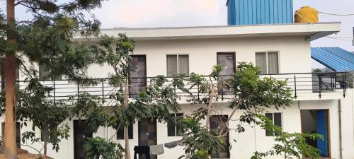 a white building with a balcony at Elevate 1478 Inn in Nandigunda