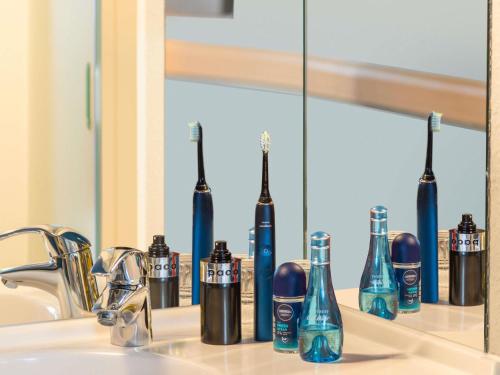 a bathroom sink with two toothbrushes sitting on a mirror at Ibis budget Hamburg Quickborn in Quickborn