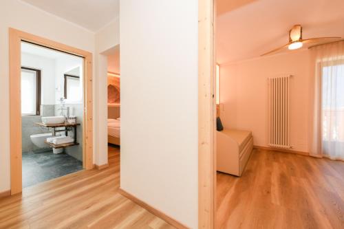 a room with a mirror and a bedroom with a bed at Hotel Denny in Pinzolo
