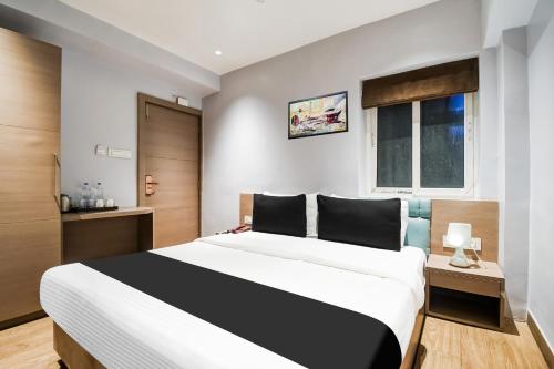 a bedroom with a large bed and a window at Hotel O Sivalika Inn in Kolkata