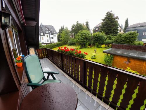 a balcony with a chair and a view of a garden at Ferienwohnungen Anders in Braunlage