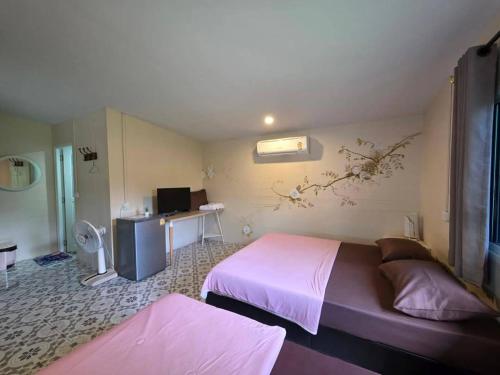 a bedroom with a bed and a desk with a computer at บ้านในสวนรีสอร์ทBannnaisuan Resort in Prachuap Khiri Khan