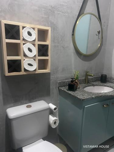 a bathroom with a toilet and a sink and a mirror at Villagio Vistamar Ilha Comprida in Ilha Comprida