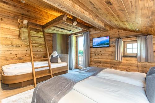 a bedroom with two bunk beds in a log cabin at Hauserhof- Urlaub am Bauernhof inklusive Sommercard in Bramberg am Wildkogel