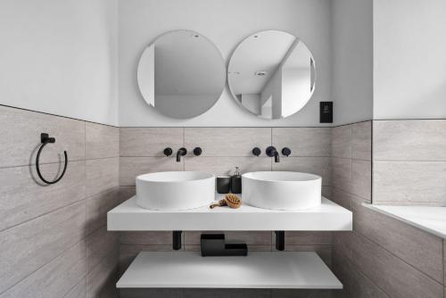 two sinks in a bathroom with two mirrors at Golden Vanity Suite - Sea View - Free Wi-Fi in Brixham