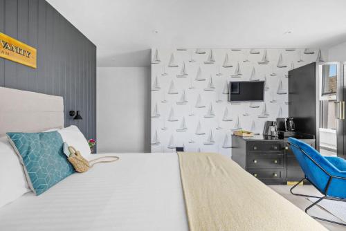 a bedroom with a bed and a blue chair at Golden Vanity Suite - Sea View - Free Wi-Fi in Brixham