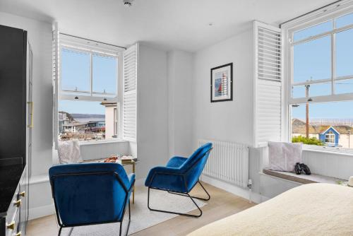 a bedroom with two blue chairs and a bed at Golden Vanity Suite - Sea View - Free Wi-Fi in Brixham