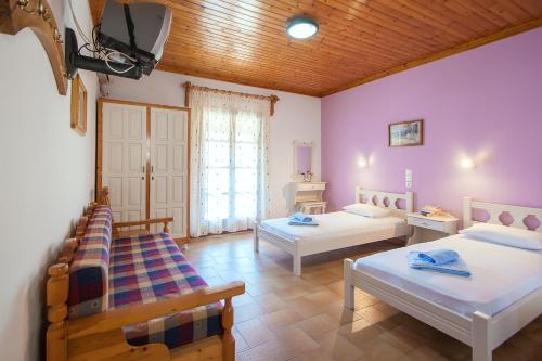 a room with two beds and a tv in it at Angela studios in Troulos