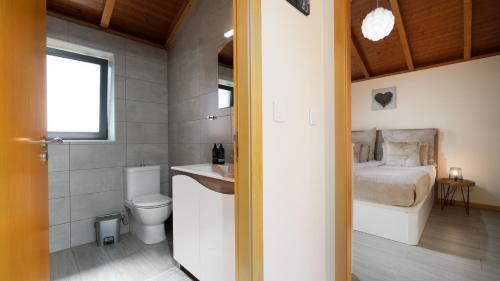 a bathroom with a bed and a sink and a toilet at Casa da Felicidade by LovelyStay in Prazeres