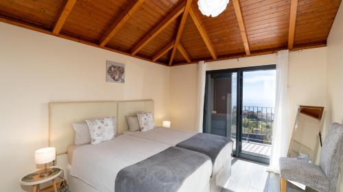 a bedroom with a large bed and a balcony at Casa da Felicidade by LovelyStay in Prazeres