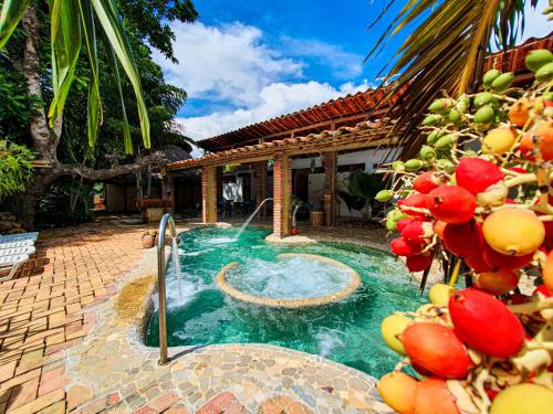 a swimming pool with a fountain in front of a house at Hotel Terra Barichara in Barichara