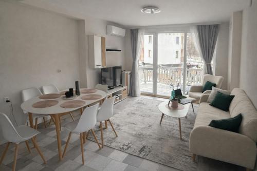 a living room with a table and a couch at Апартамент Зора in Chepelare