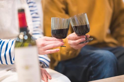 two people holding glasses of wine in their hands at wanderlust STAY in Kofu