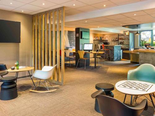a lobby with tables and chairs and a cafeteria at ibis Paris Saint-Denis Stade Sud in Saint-Denis