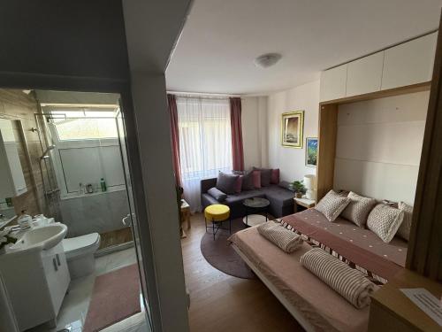 a bedroom with a large bed and a bathroom at Moderan Studio na Trgu Republike - Centar in Podgorica