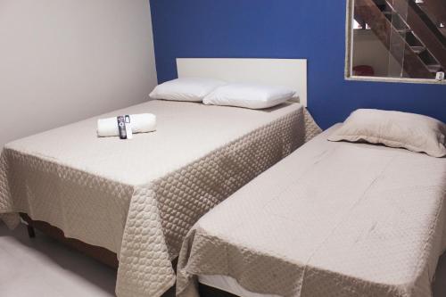 two beds with towels on them in a room at Pousada Porto Maresias in Cabo Frio