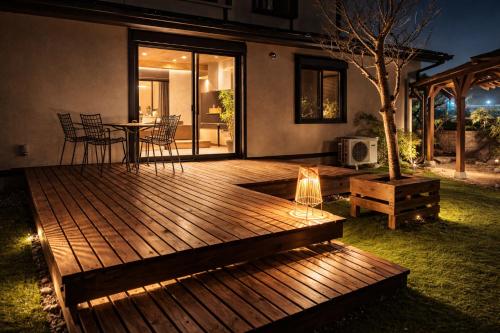 a wooden deck with a table and chairs in a yard at Biwako Villa 縁 in Takashima