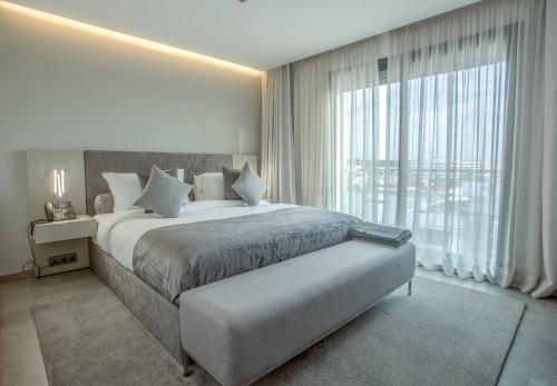 a bedroom with a large bed and a large window at Makass Appart Hotel in Rabat
