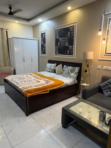 a bedroom with a large bed and a couch at Rao Studio in Noida
