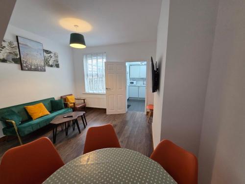 a living room with a green couch and a table at Fantastic 3-Bedroom House in Crawley - 10 mins from Gatwick in Crawley
