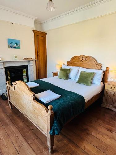 a bedroom with a large bed with a fireplace at Nethercoombe House in Portland