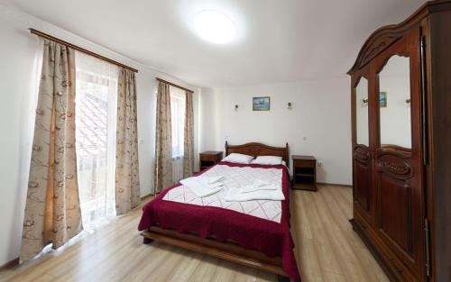a bedroom with a bed and a large window at Садиба Буркут in Kvasy