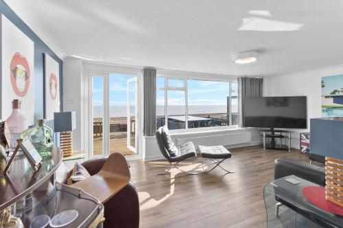 a living room with a view of the ocean at Luxury Beachfront The Cozy Clam in Pevensey