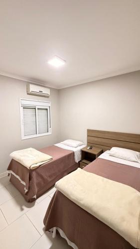 a room with two beds and a window at Imbau Palace Hotel in Imbau