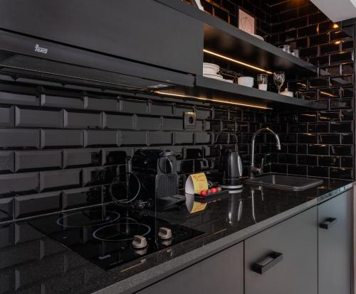 a kitchen with black brick walls and a black counter top at Gold By Marina - Adults only in Playa del Ingles