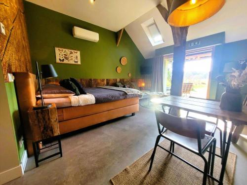 a bedroom with a bed and a table with a chair at 't Buitenverblijf Erve Punte in Losser