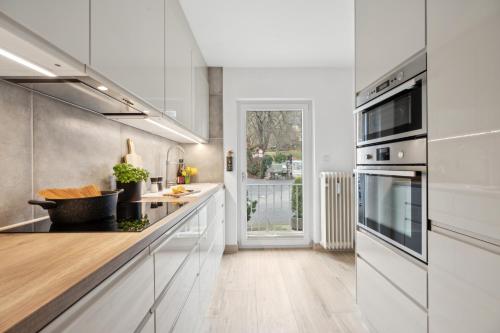 a kitchen with white cabinets and a counter top at Modernes Design-Apartment am Drachenfels in Bad Honnef am Rhein