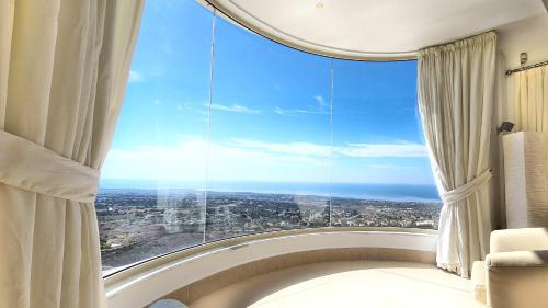 a room with a large window with a view of the ocean at Breathtaking Panoramic Villa Sea View Infinity Pool in Tala